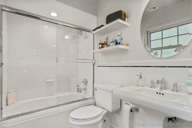 3918 S Evanston Ave, Tulsa, OK 74105 - full bath with ornamental molding, enclosed tub / shower combo, tile walls, and wainscoting
