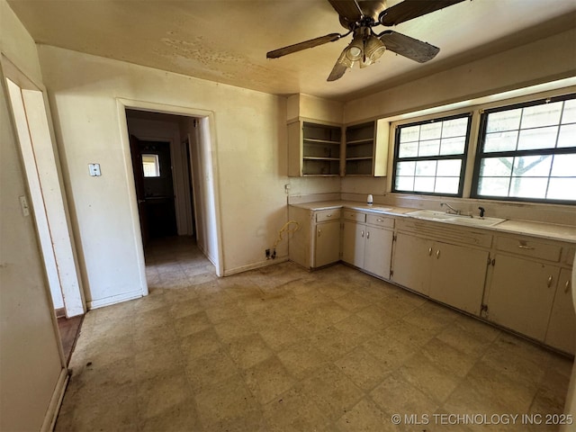 611 Crutchmer Ave, Okmulgee, OK 74447 - kitchen with light countertops, open shelves, a ceiling fan, and light floors
