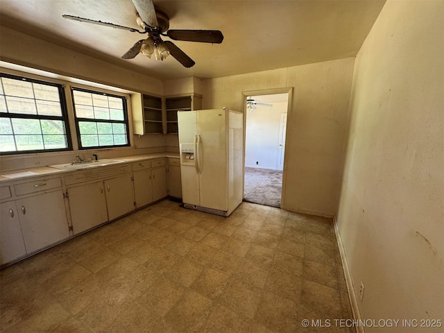 611 Crutchmer Ave, Okmulgee, OK 74447 - kitchen with white refrigerator with ice dispenser, light countertops, a ceiling fan, light floors, and open shelves