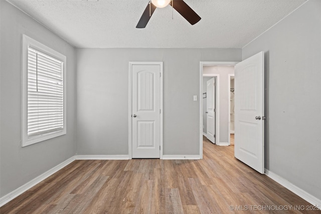 345 N Pine, Dewey, OK 74029 - unfurnished bedroom with a textured ceiling, wood finished floors, and ceiling fan