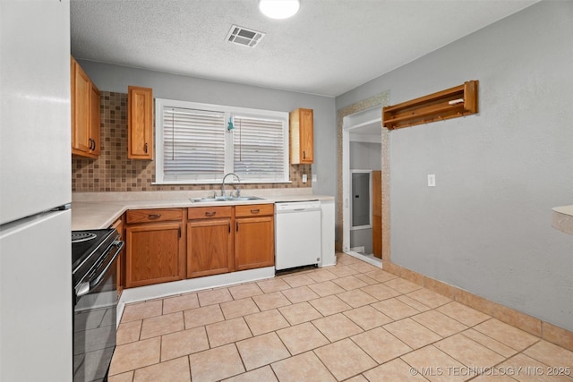 345 N Pine, Dewey, OK 74029 - kitchen featuring white appliances, light countertops, decorative backsplash, and a textured ceiling