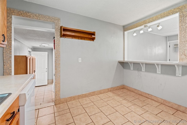 345 N Pine, Dewey, OK 74029 - unfurnished dining area with a textured ceiling, light tile patterned floors, and rail lighting