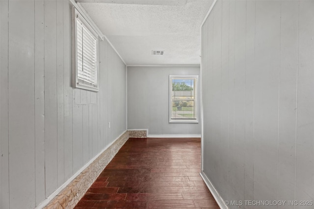 345 N Pine, Dewey, OK 74029 - unfurnished room featuring hardwood / wood-style flooring, wood walls, and a textured ceiling