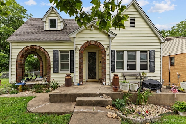 817 S Stockton, Ada, OK 74820 - view of front of property featuring a shingled roof, a porch, and brick siding