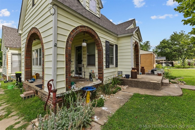 817 S Stockton, Ada, OK 74820 - view of side of home featuring a shingled roof and a yard