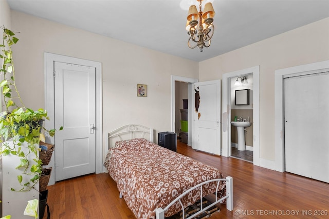 817 S Stockton, Ada, OK 74820 - bedroom featuring a chandelier, wood finished floors, and ensuite bath