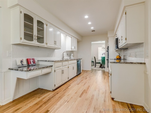 5610 S 75th E Pl, Tulsa, OK 74145 - kitchen featuring stainless steel appliances, backsplash, light wood-style floors, white cabinets, and dark stone countertops