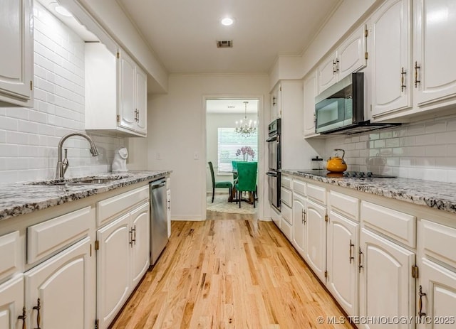 5610 S 75th E Pl, Tulsa, OK 74145 - kitchen featuring black appliances, a chandelier, white cabinets, crown molding, and light wood-style flooring