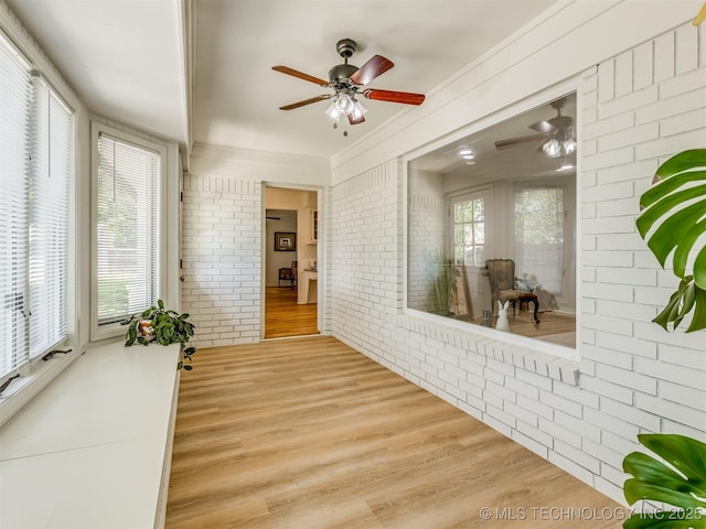 5610 S 75th E Pl, Tulsa, OK 74145 - unfurnished sunroom featuring brick wall, wood finished floors, healthy amount of natural light, and crown molding