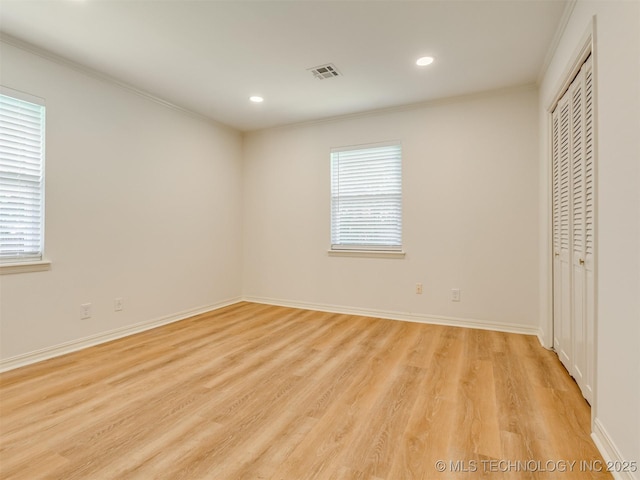 5610 S 75th E Pl, Tulsa, OK 74145 - unfurnished bedroom with crown molding, light wood-style floors, multiple windows, recessed lighting, and a closet