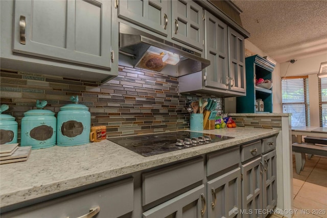 920 Ridge Oak Rd, Sapulpa, OK 74066 - kitchen with under cabinet range hood, gray cabinets, black electric stovetop, a textured ceiling, and light tile patterned floors