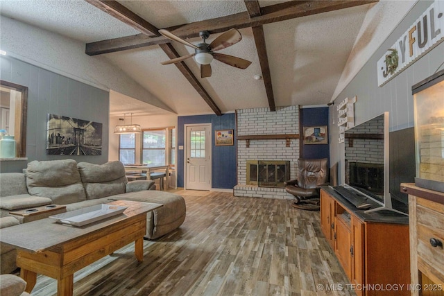 920 Ridge Oak Rd, Sapulpa, OK 74066 - living area featuring a brick fireplace, a textured ceiling, wood finished floors, a ceiling fan, and wood walls