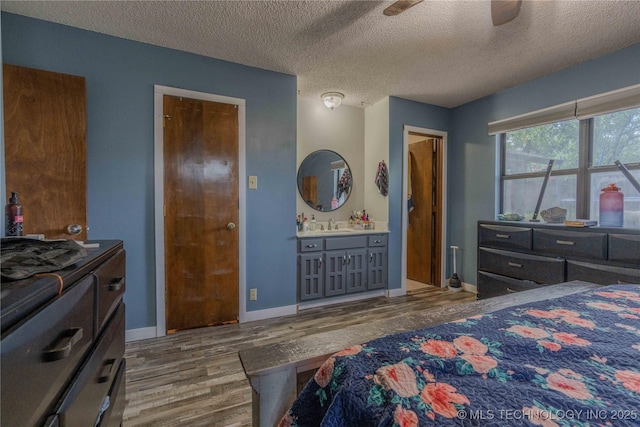 920 Ridge Oak Rd, Sapulpa, OK 74066 - bedroom with wood finished floors, a textured ceiling, and connected bathroom