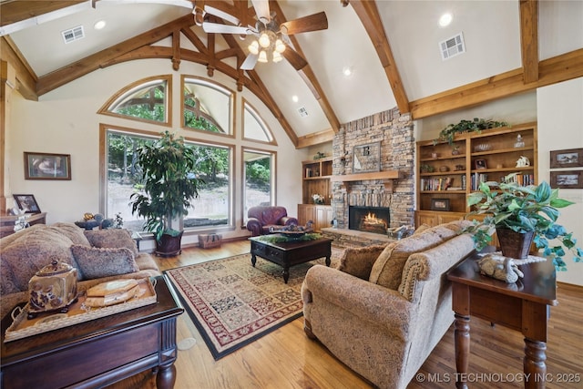 7355 E 453rd Rd, Claremore, OK 74017 - living room with a stone fireplace, a ceiling fan, beamed ceiling, wood finished floors, and high vaulted ceiling
