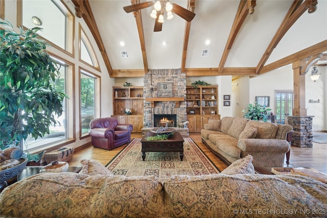 7355 E 453rd Rd, Claremore, OK 74017 - living area featuring high vaulted ceiling, a ceiling fan, a stone fireplace, beam ceiling, and plenty of natural light