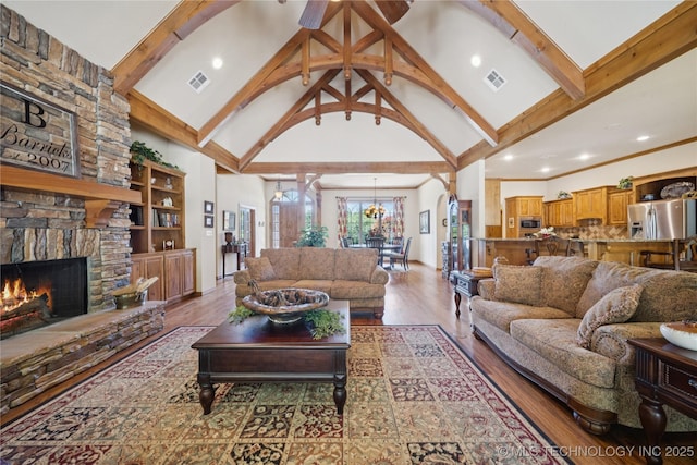 7355 E 453rd Rd, Claremore, OK 74017 - living room featuring high vaulted ceiling, a stone fireplace, beamed ceiling, wood finished floors, and recessed lighting