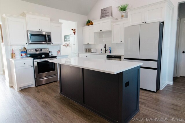 11940 County Road 3513, Ada, OK 74820 - kitchen with stainless steel appliances, backsplash, lofted ceiling, white cabinets, and a kitchen island