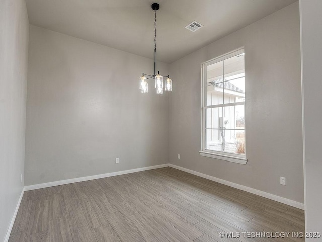 12098 County Road 3513th Loop, Ada, OK 74820 - unfurnished room featuring plenty of natural light, wood finished floors, and a chandelier