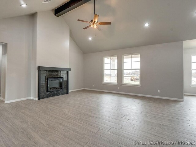 12098 County Road 3513th Loop, Ada, OK 74820 - unfurnished living room featuring beamed ceiling, ceiling fan, a tiled fireplace, wood finished floors, and high vaulted ceiling