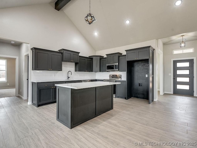 12098 County Road 3513th Loop, Ada, OK 74820 - kitchen featuring a center island, light countertops, stainless steel appliances, beam ceiling, and tasteful backsplash