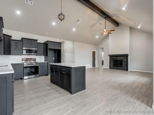 12098 County Road 3513th Loop, Ada, OK 74820 - kitchen featuring stainless steel appliances, beam ceiling, ceiling fan, tasteful backsplash, and light countertops