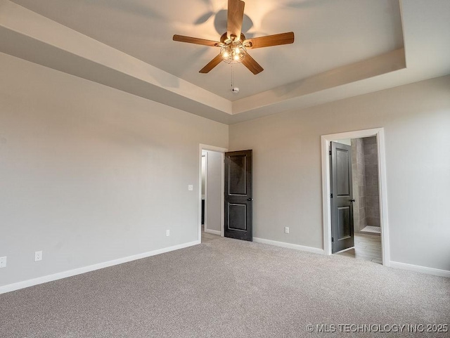 12098 County Road 3513th Loop, Ada, OK 74820 - unfurnished bedroom featuring carpet floors, a tray ceiling, ensuite bathroom, and a ceiling fan