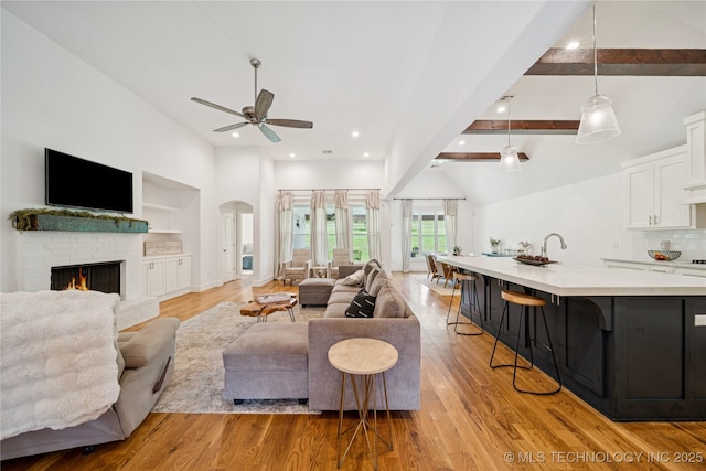 7383 S 288th E Ave, Broken Arrow, OK 74014 - living area with ceiling fan, light wood finished floors, a fireplace, recessed lighting, and arched walkways