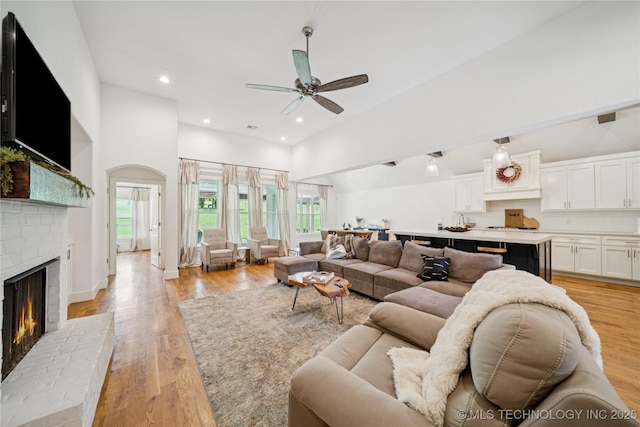 7383 S 288th E Ave, Broken Arrow, OK 74014 - living room featuring high vaulted ceiling, a brick fireplace, a ceiling fan, light wood-style flooring, and recessed lighting