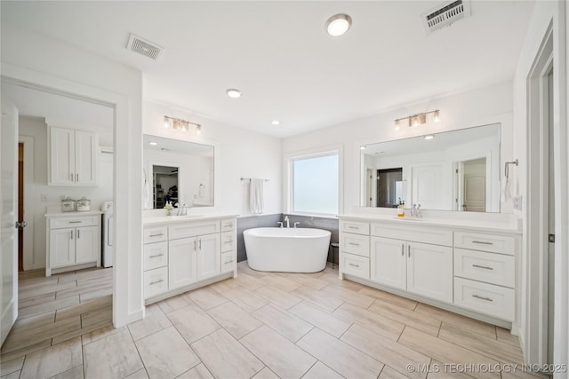 7383 S 288th E Ave, Broken Arrow, OK 74014 - full bath featuring two vanities, a freestanding tub, and recessed lighting