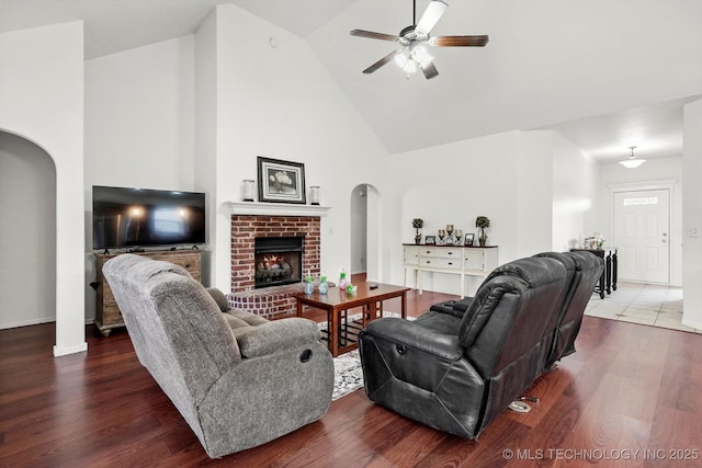 7316 E Knoxville St, Broken Arrow, OK 74014 - living room featuring arched walkways, high vaulted ceiling, ceiling fan, a fireplace, and wood finished floors