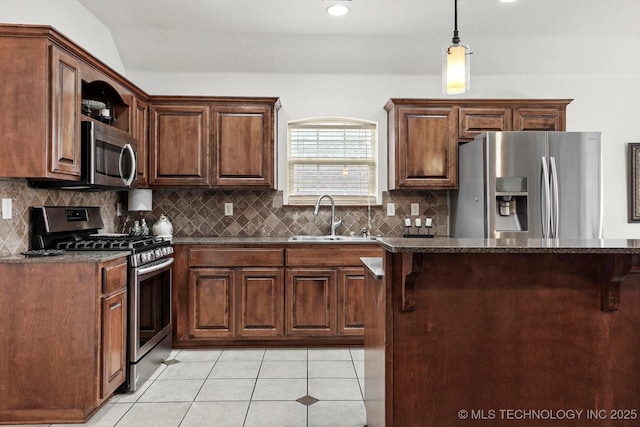 7316 E Knoxville St, Broken Arrow, OK 74014 - kitchen featuring appliances with stainless steel finishes, light tile patterned floors, tasteful backsplash, dark stone counters, and hanging light fixtures