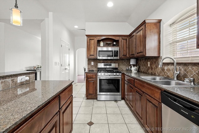 7316 E Knoxville St, Broken Arrow, OK 74014 - kitchen featuring stainless steel appliances, backsplash, light tile patterned floors, arched walkways, and recessed lighting
