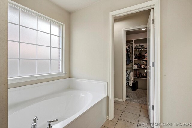 7316 E Knoxville St, Broken Arrow, OK 74014 - bathroom featuring a bath, tile patterned flooring, a walk in closet, and plenty of natural light