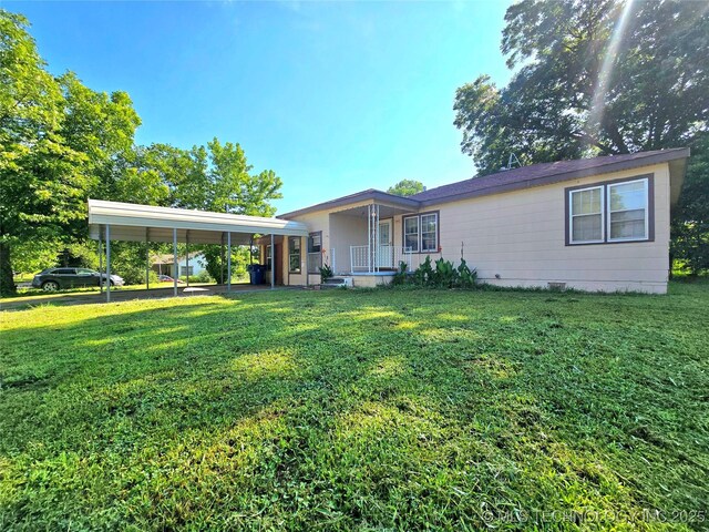 305 Chronister Ave, Drumright, OK 74030 - back of house with a detached carport, a lawn, and covered porch
