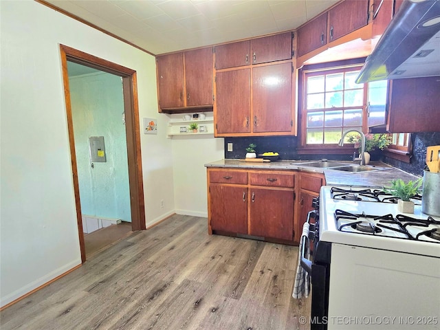 305 Chronister Ave, Drumright, OK 74030 - kitchen with ventilation hood, range with gas cooktop, light wood finished floors, and brown cabinetry