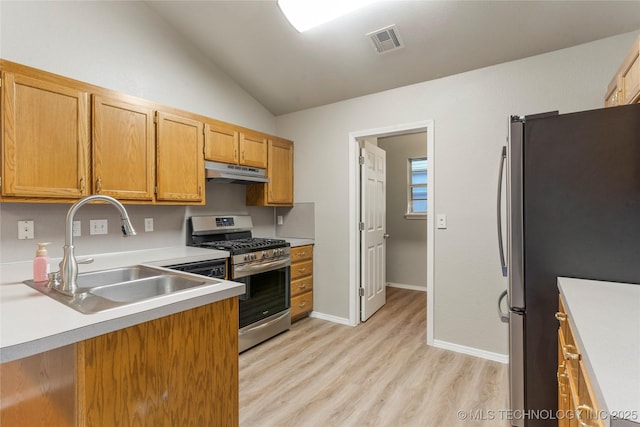 715 S Muskogee St, Sapulpa, OK 74066 - kitchen with appliances with stainless steel finishes, vaulted ceiling, light wood-style floors, light countertops, and under cabinet range hood