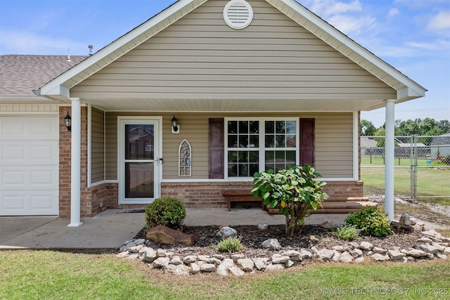 24 Faye Ave, Inola, OK 74036 - view of front of property with a porch, brick siding, and an attached garage