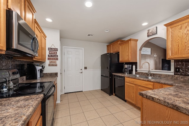 24 Faye Ave, Inola, OK 74036 - kitchen with black appliances, dark countertops, arched walkways, light tile patterned floors, and recessed lighting