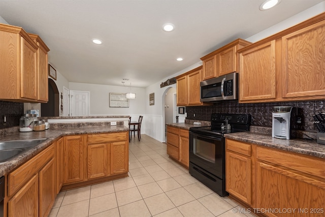 24 Faye Ave, Inola, OK 74036 - kitchen featuring arched walkways, black electric range oven, light tile patterned flooring, dark countertops, and decorative backsplash
