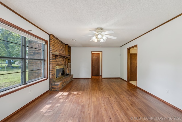 10421 S 197th E Ave, Broken Arrow, OK 74014 - unfurnished living room featuring a textured ceiling, light wood-type flooring, a ceiling fan, a fireplace, and ornamental molding