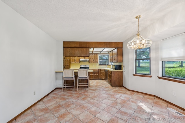 10421 S 197th E Ave, Broken Arrow, OK 74014 - kitchen featuring a chandelier, light countertops, brown cabinets, a peninsula, and a textured ceiling