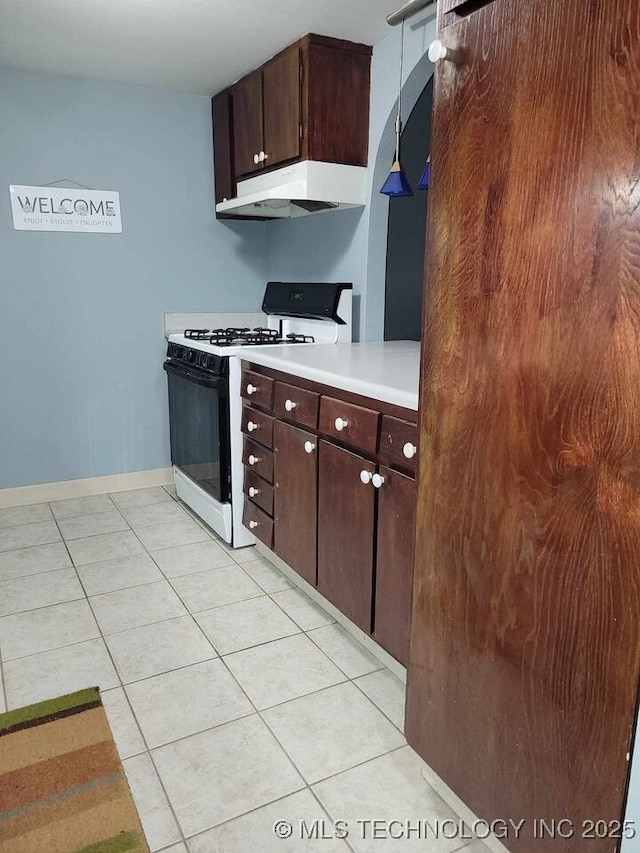 450 W 7th St Unit 704, Tulsa, OK 74119 - kitchen featuring gas stove, under cabinet range hood, light tile patterned flooring, light countertops, and dark brown cabinetry