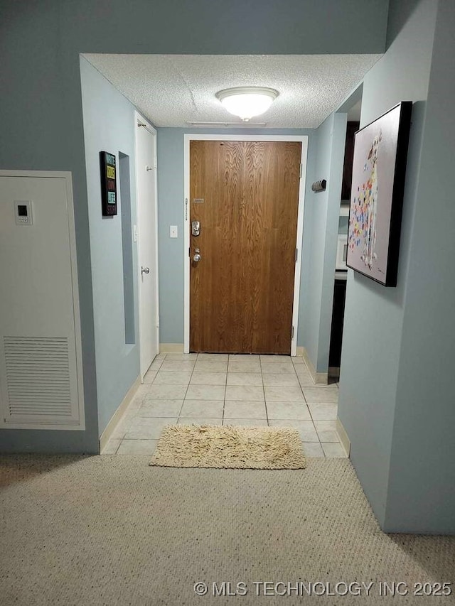 450 W 7th St Unit 704, Tulsa, OK 74119 - corridor featuring a textured ceiling, light tile patterned floors, light colored carpet, and a heating unit