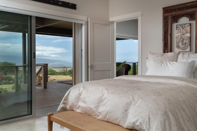 bedroom with a mountain view, access to exterior, and multiple windows