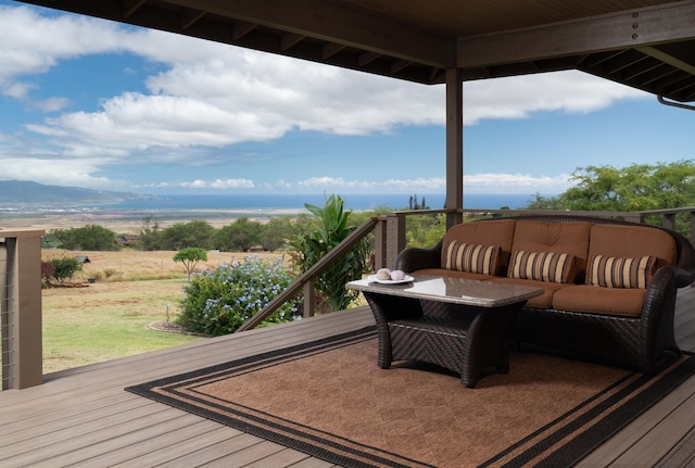 wooden terrace featuring an outdoor living space and a water view