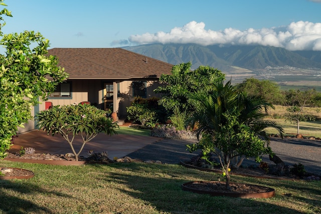 exterior space with a mountain view and a front lawn