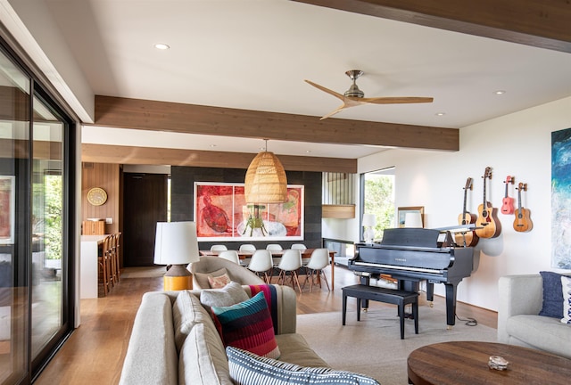 living room with beamed ceiling, wood-type flooring, and ceiling fan