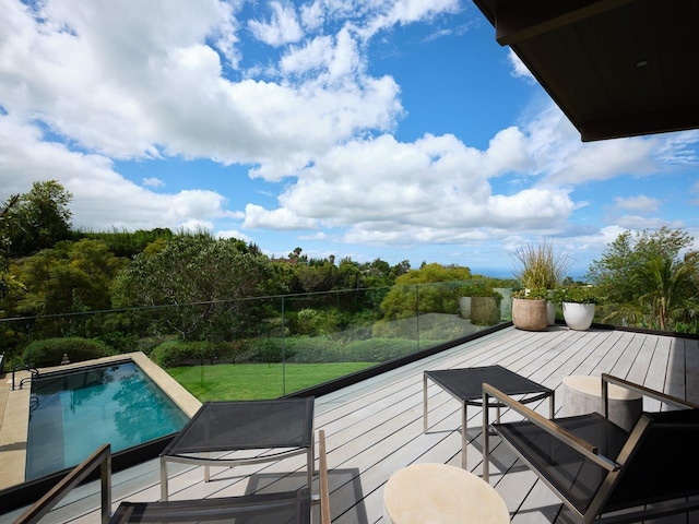 wooden deck featuring a lawn and a fenced in pool