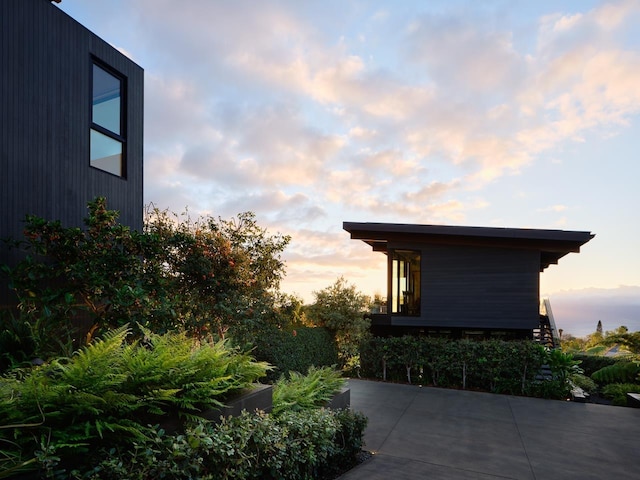 property exterior at dusk featuring a patio