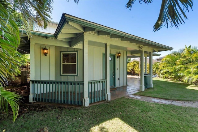 exterior space with a porch, a yard, and board and batten siding